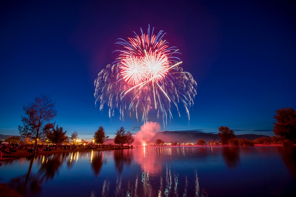 Creative night photography of fireworks and lake